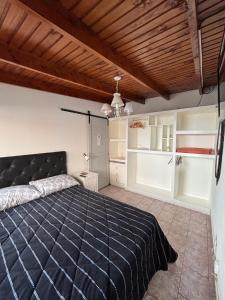 a bedroom with a large bed and a wooden ceiling at Cabaña La Nona in San Carlos de Bariloche