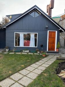 a blue house with a red door at Cabaña La Nona in San Carlos de Bariloche