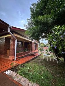 a brick house with a bench in the yard at La Rosa House - Central house in Eldorado in Eldorado