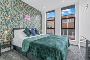 a bedroom with a bed with a green blanket at 2 BR Luxury Central Apartment Near Colmore Row in Birmingham