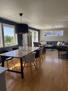 Una sala de estar con una mesa y sillas y un sofá. en Korssundvegen 230, en Korssund