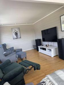 Una sala de estar con un sofá y un televisor de pantalla plana. en Korssundvegen 230, en Korssund