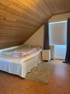 una cama en una habitación con techo de madera en Korssundvegen 230, en Korssund