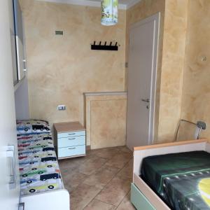 a room with two beds in a room with a door at Appartamento Nonna Rosa in Tirano