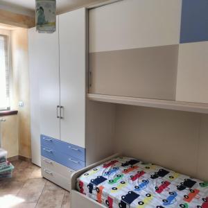 a bedroom with a bed and a cabinet at Appartamento Nonna Rosa in Tirano