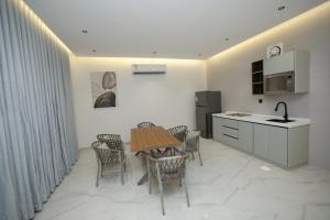 a kitchen with a table and chairs and a kitchen with a sink at شاليهات البدر الحمدانية in Jeddah