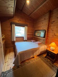 a bedroom with a bed in a wooden cabin at Natur pur, Haus mit großen Garten am Wald in Langendorf