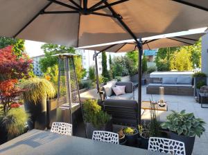 a patio with a table and an umbrella at Chambre avec jacuzzi extérieur in Strasbourg
