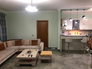 a living room with a couch and a table at Villa Olive Tree in Fier