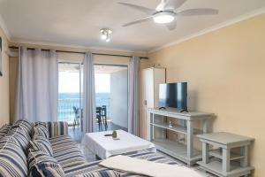Μια τηλεόραση ή/και κέντρο ψυχαγωγίας στο Comfy Beachfront Apt! Shared Pool!