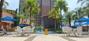 a group of chairs and umbrellas next to a pool at Service kl apartment times square in Kuala Lumpur