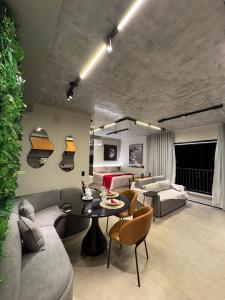 un salon avec un canapé et une table dans l'établissement Studio Luxuoso no ID Vida Urbana Inteligente mais Alexa, à Goiânia