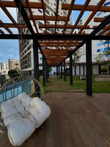 un matelas posé sur une terrasse en bois avec auvent dans l'établissement Studio Luxuoso no ID Vida Urbana Inteligente mais Alexa, à Goiânia