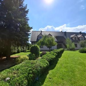 a house with a yard with bushes and trees at Apartamenty TUTERRA I in Zabagnie +39 photos