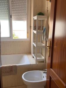 a bathroom with a tub and a toilet and a sink at Sevilla. Gerena Casa Rural para familia o profesionales in Gerena