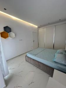 a bedroom with a bed in a room with marble floors at Eldi's Home in Vlorë