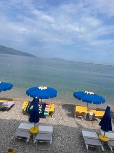 a beach with chairs and umbrellas and the ocean at Eldi's Home in Vlorë