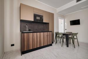 a kitchen with a sink and a table with chairs at Luxury Design Apartment-2 Steps from Duomo in Milan