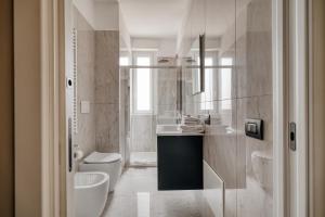 a white bathroom with a sink and a toilet at Luxury Design Apartment-2 Steps from Duomo in Milan