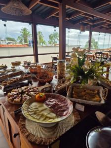 a table topped with plates of food and bread at Terra Bella Pousada in Morro de São Paulo +80 photos