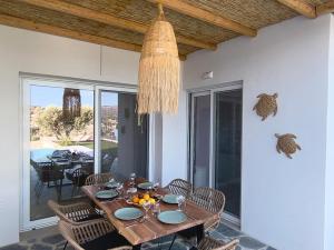 a dining room with a table and chairs and a chandelier at Villa Livia- panoramic view with pool and beautiful garden in Pitsidia