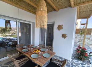 a dining room with a wooden table and chairs at Villa Livia- panoramic view with pool and beautiful garden in Pitsidia