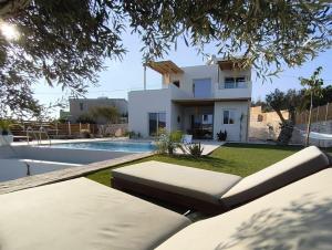 a view of a house with a swimming pool at Villa Livia- panoramic view with pool and beautiful garden in Pitsidia