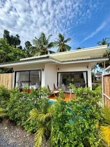 a small white house with trees in the background at Srithanu Escape 3 in Ban Madua Wan