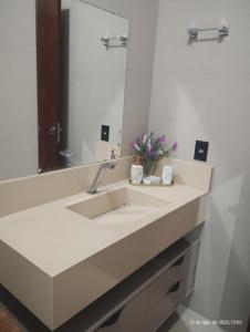 a bathroom with a sink and a mirror at Quarto com ar e banheiro estacionamento e Wi-Fi in Sinop