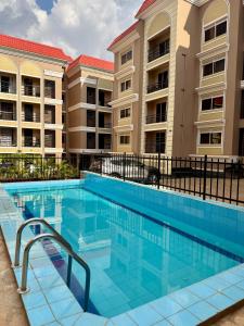 a swimming pool in front of a building at Lipsy Homes Kungu in Kampala