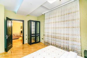 a living room with a bed and a window at Bakı Rezidens Apartment Nizami str in Baku