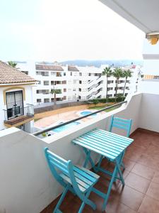 a balcony with a table and chairs and a swimming pool at Plaza de la Vendimia in Manilva