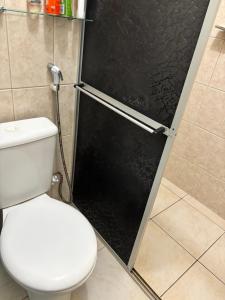 a bathroom with a toilet and a black door at Alugo andar inteiro de casa para a COP30 in Ananindeua