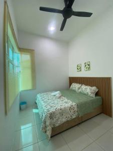 a bedroom with a bed with a ceiling fan at Simfoni Jitra Homestay in Jitra
