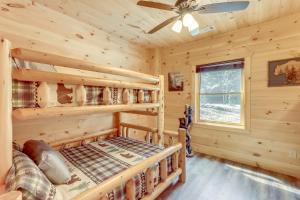 a log cabin bedroom with a bed and a ceiling fan at Cabin Near Blue Ridge with Fire Pit and Large Deck in Mineral Bluff