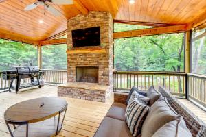 a screened in porch with a couch and a fireplace at Cabin Near Blue Ridge with Fire Pit and Large Deck in Mineral Bluff