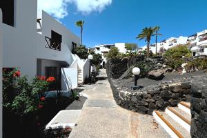 a walkway next to a building and a stone wall at Tabaiba Place in Tías