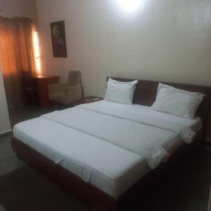 Un dormitorio con una cama grande con sábanas y almohadas blancas. en Finishing Touches Hotel, en Lekki
