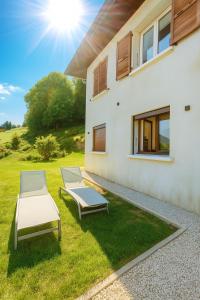 two lounge chairs on the grass next to a house at Cocon privé avec vue montagne exceptionnelle in Verrens-Arvey