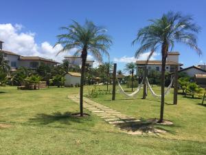 a hammock between two palm trees in a yard at Apartamento em Subaúma no Resort Tree Bies in Entre Rios