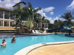 two people in the swimming pool at a resort at Apartamento em Subaúma no Resort Tree Bies in Entre Rios
