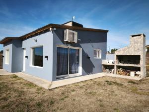 a blue house with a window and a building at Altura serrana in Villa Yacanto