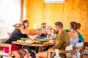 a group of people sitting at a table drinking wine at The seven saints - luxury camp - lodges & tents - desert activities in El Karia