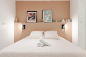 Un dormitorio con una cama blanca con tres cuadros en la pared. en La Petite Bégude Design & Spa, en La Bégude-de-Mazenc 6 fotos más