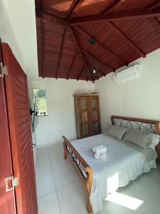 a bedroom with a bed and a wooden ceiling at Búzios Apartamento Paraiso ll in Búzios +2 photos