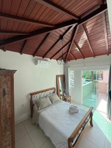 a bedroom with a bed with a wooden ceiling at Búzios Apartamento Paraiso ll in Búzios