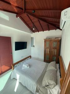a bedroom with a bed and a flat screen tv at Búzios Apartamento Paraiso ll in Búzios