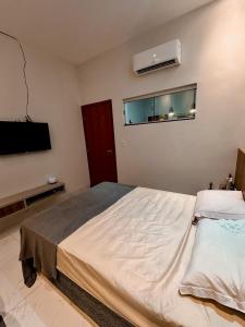 Un dormitorio con una cama grande y un televisor de pantalla plana. en Apartamento - Centro de Redenção, en Redenção