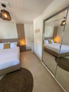 a hotel room with two beds and a mirror at Rock Palma Apartments - Cozy, spacious and family friendly in Noord