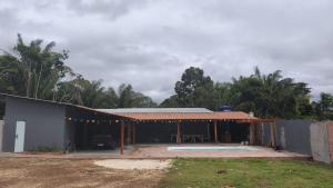 a house with a patio and a table outside at Chácara Baruk in Iranduba +5 photos